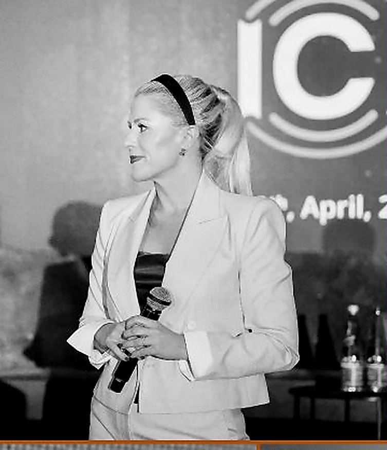 Elena Andolin Mueller moderating with a handheld microphone